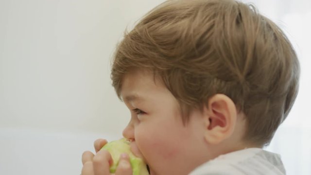 Close up of a boy eating an apple