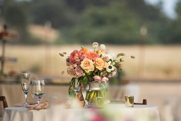 Bridal bouquet sitting in a vase of water at the table at a reception