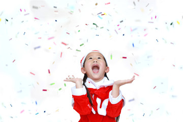 Happy child girl in Santa costume dress with colorful confetti ribbon paper thrown on white background. Merry Christmas and Happy New Year Concept.