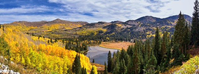 Silver Lake by Solitude and Brighton Ski resort in Big Cottonwood Canyon. Panoramic Views from the hiking and boardwalk trails of the surrounding mountains, aspen and pine trees in brilliant fall autu - obrazy, fototapety, plakaty