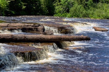 A short rowboat ride takes visitors to an island in the middle of Michigan's Lower Tahquamenon Falls, where a short hike can put you in the falls themselves, though it's dangerous and not recommended.
