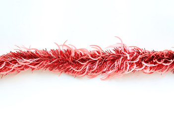 Red colors bunch fur or Christmas tree tinsel garland on white background. Christmas and New year celebration.