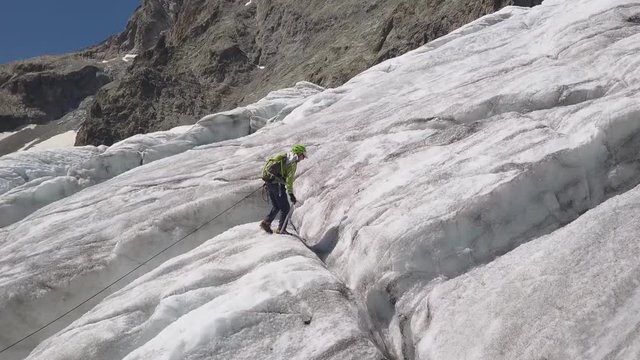 old man climbing upon a steep gletsjer