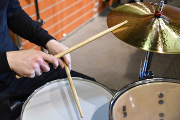  Professional drum set closeup. Man drummer with drumsticks playing drums and cymbals, on the live...
