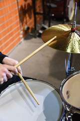  Professional drum set closeup. Man drummer with drumsticks playing drums and cymbals, on the live...