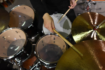 Fototapeta na wymiar Professional drum set closeup. Man drummer with drumsticks playing drums and cymbals, on the live music rock concert or in recording studio 