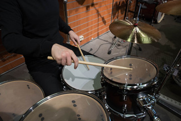 Professional drum set closeup. Man drummer with drumsticks playing drums and cymbals, on the live...