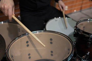 Professional drum set closeup. Man drummer with drumsticks playing drums and cymbals, on the live music rock concert or in recording studio   