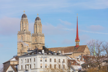 Fototapeta na wymiar Buildings of the historic part of the city of Zurich along the Limmat river in winter, towers of the famous Grossmunster cathedral above them
