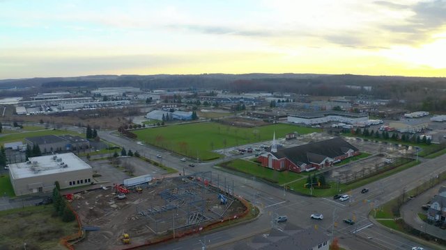Drone aerial view of Kitchener suburbs with construction site and church at sunset