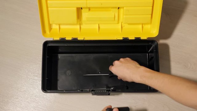 male hand opens box with instruments for repair.