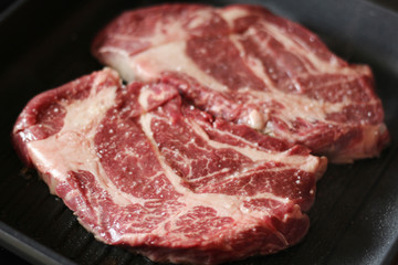 Raw steaks cooked on the pan