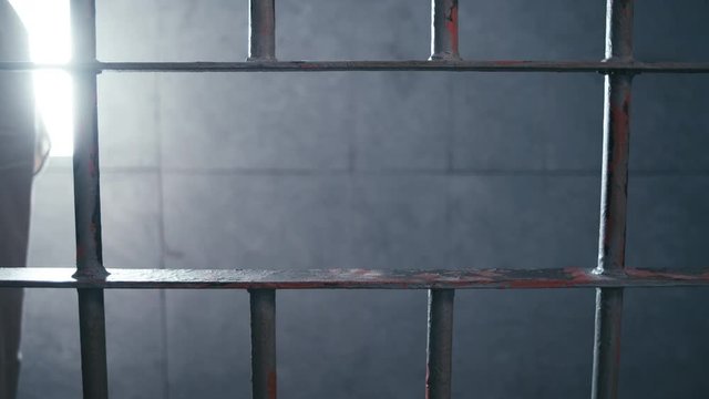 Medium shot of a prisoner pacing in his cell.
