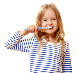 A little girl in striped pajamas is brushing her teeth with a toothbrush. The concept of daily...