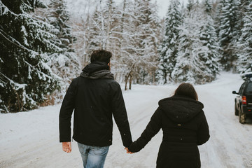 young couple walking in winter park