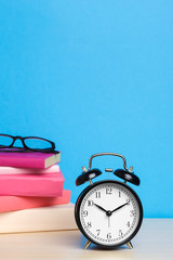 Back to school background with books and alarm clock