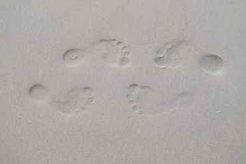 Closeup of two couple of footprints  in the sand on the beach in the opposite side. Symbol of love forever.