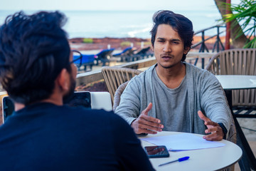 Indian young business people businessman freelancer working outdoors chaise lounge on the beach...