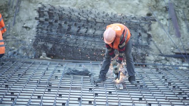 Builder cuts the rebar with sparks