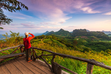 The girl in red jacket touring on the beautiful mountain.