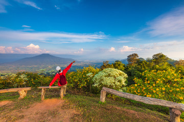 The girl in red jacket touring on the beautiful mountain.