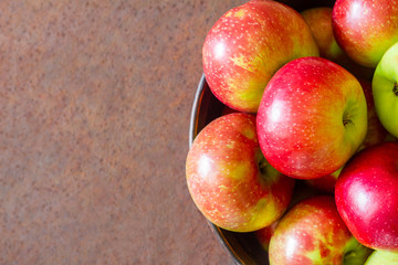 Fresh apples on a metal plate against a rusty metal surface. Top view. Closeup, selective focus