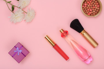 Obraz na płótnie Canvas Gift box, flowers and women cosmetics on a pink background.