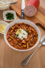 Typische DDR Soljanka Suppe in Schale mit Schmand und Zitrone