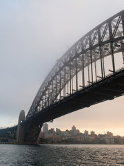 Sydney Harbour Bridge view under sunrise light and fog.