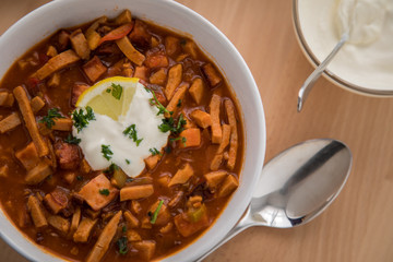 Typische DDR Soljanka Suppe in Schale mit Schmand und Zitrone