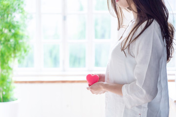 young asian woman holding heart symbol