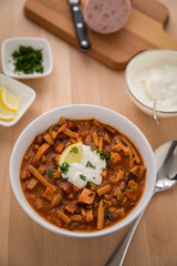 Typische DDR Soljanka Suppe in Schale mit Schmand und Zitrone