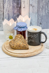 rustic breakfast still life with heart shaped whole grain roll, homemade jam and coffee mug with chalk text for you