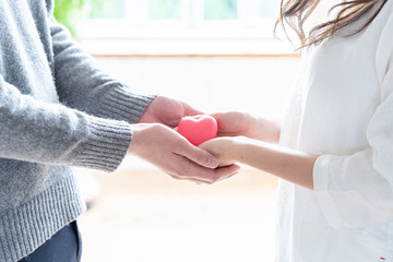 young asian woman holding heart symbol