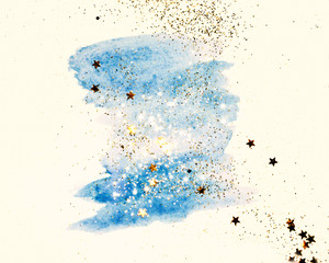 Golden glitter and glittering stars on abstract blue watercolor splash in vintage nostalgic colors.