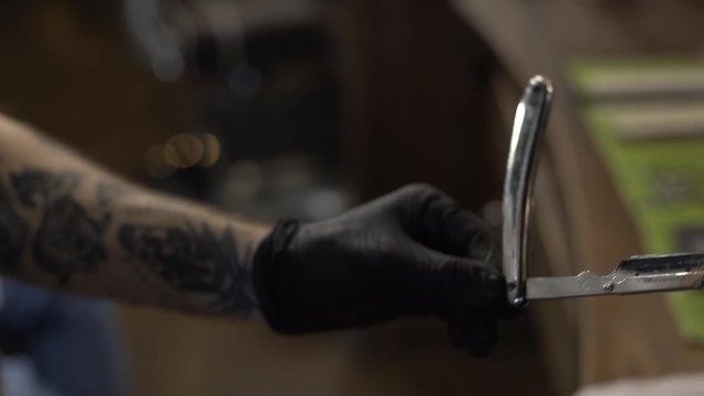 Fast cleaning of a shaving blade with a special sprayer after shaving in a barbershop. Close-up concept