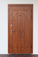 Vertical photo of beautiful metal entrance door on white plaster wall new comfort house