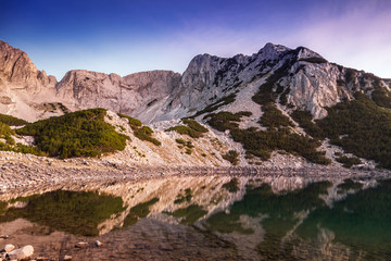 Mountain peak reflected in the water of the lake at sunset