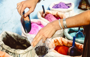 Obraz premium Young tourist buying coloured pigments as souvenir in Chefchaouen