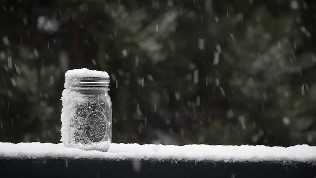 Snow falling on a mason jar