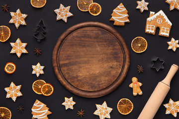 Gingerbread cookies and round wooden board, top view