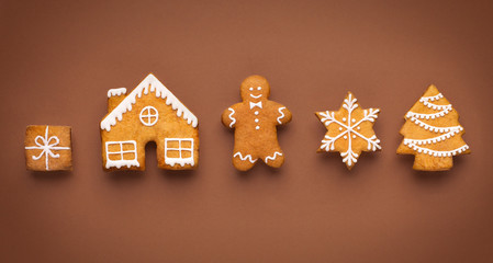 Assortment of homemade gingerbread cookies on brown background