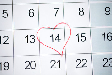 valentines day and holidays concept - close up of calendar sheet with 14th february date marked by red heart shape