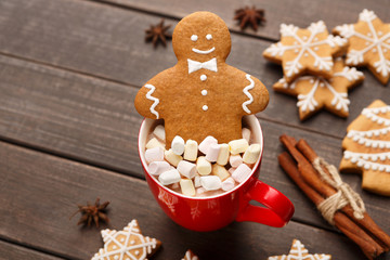 Gingerbread cookie in cup of cocoa with marshmallows
