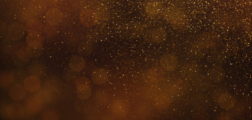Fototapeta na wymiar Dark brown background with golden sparkling lights