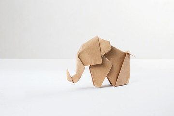 Brown paper origami elephant isolated on white background