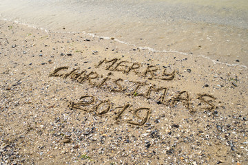 Merry Christmas written on tropical beach sand, copy space. Holiday concept