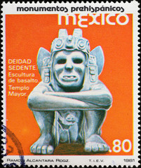 Aztec sculpture of deity sitting on postage stamp