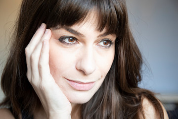 Young woman close-up portrait. Caucasian with brown long hair and bangs.