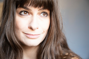 Fototapeta premium Young woman close-up portrait. Caucasian with brown long hair and bangs.